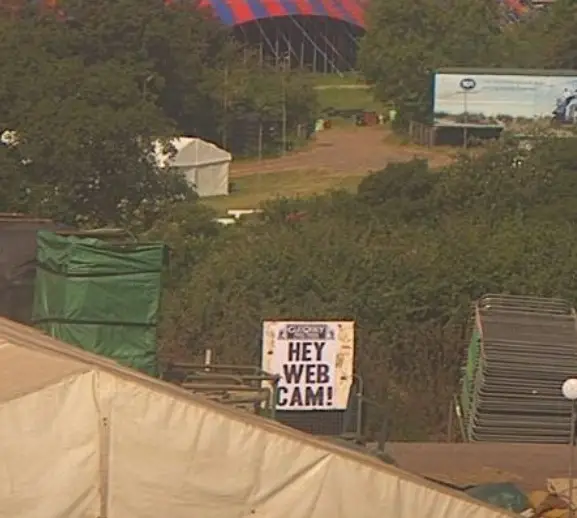 Glastonbury Festival Webcam image of a Glastonbury Free Press poster saying "Hey Web Cam!"